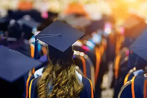 Rear view of the university graduates line up for degree award in the university graduation ceremony.